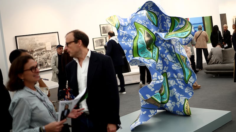 A visitor studies an artwork by British artist Yinka Shonibare, "Wind Sculpture in Bronze (SG)", 2023, during the Frieze Art Fair at Regent's Park in London on October 9, 2024.